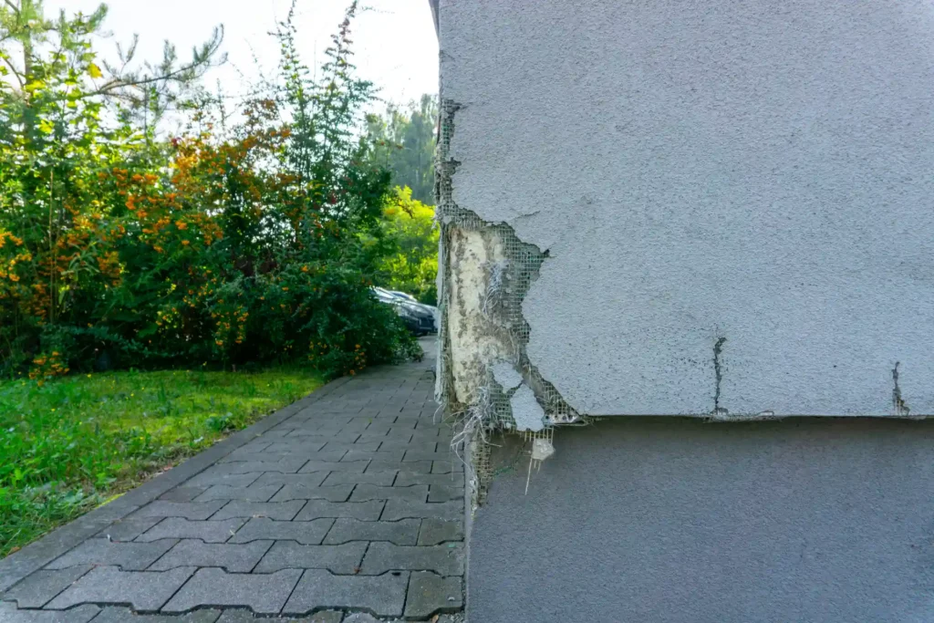 Lakóparki és panel lakás javítások Súlyosan omladozó és megrepedt régi vakolat egy falon Székesfehérváron - az OtthonPro Kivitelezés szakemberei a megfelelő javítási módszert alkalmazzák.